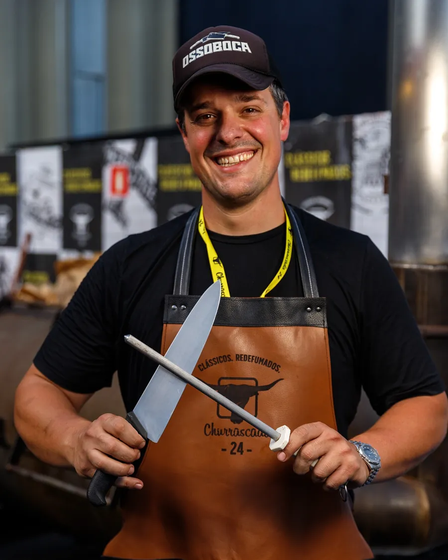 Chef Roberto Bocabello segurando faca e chaira, de avental Ossoboca