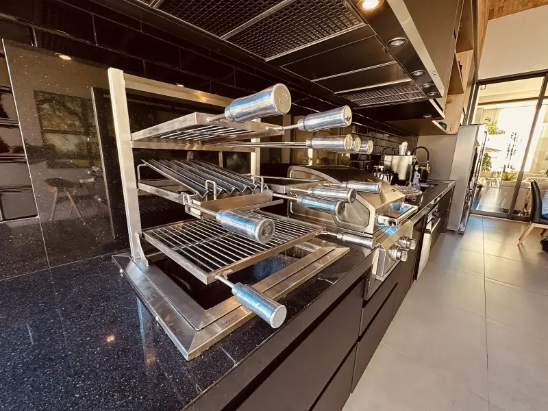 Grill Ossoboca completo com grelhas, espetos e chapa em bancada de granito preto